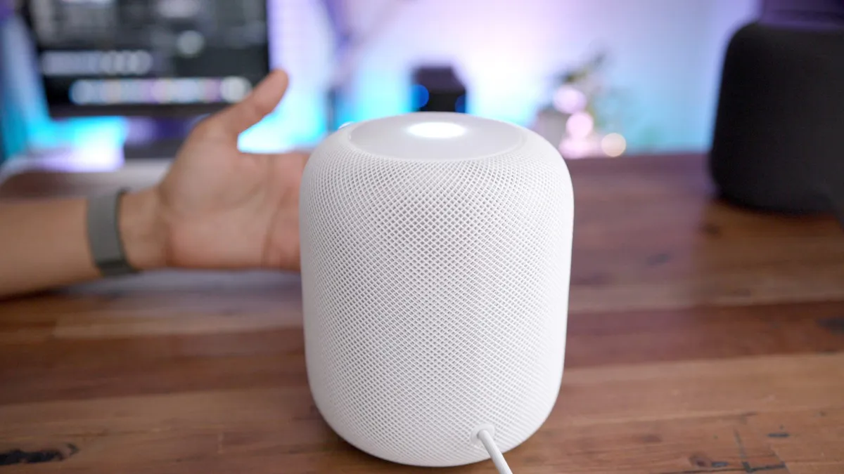 Smart speaker on a table beside a smartphone