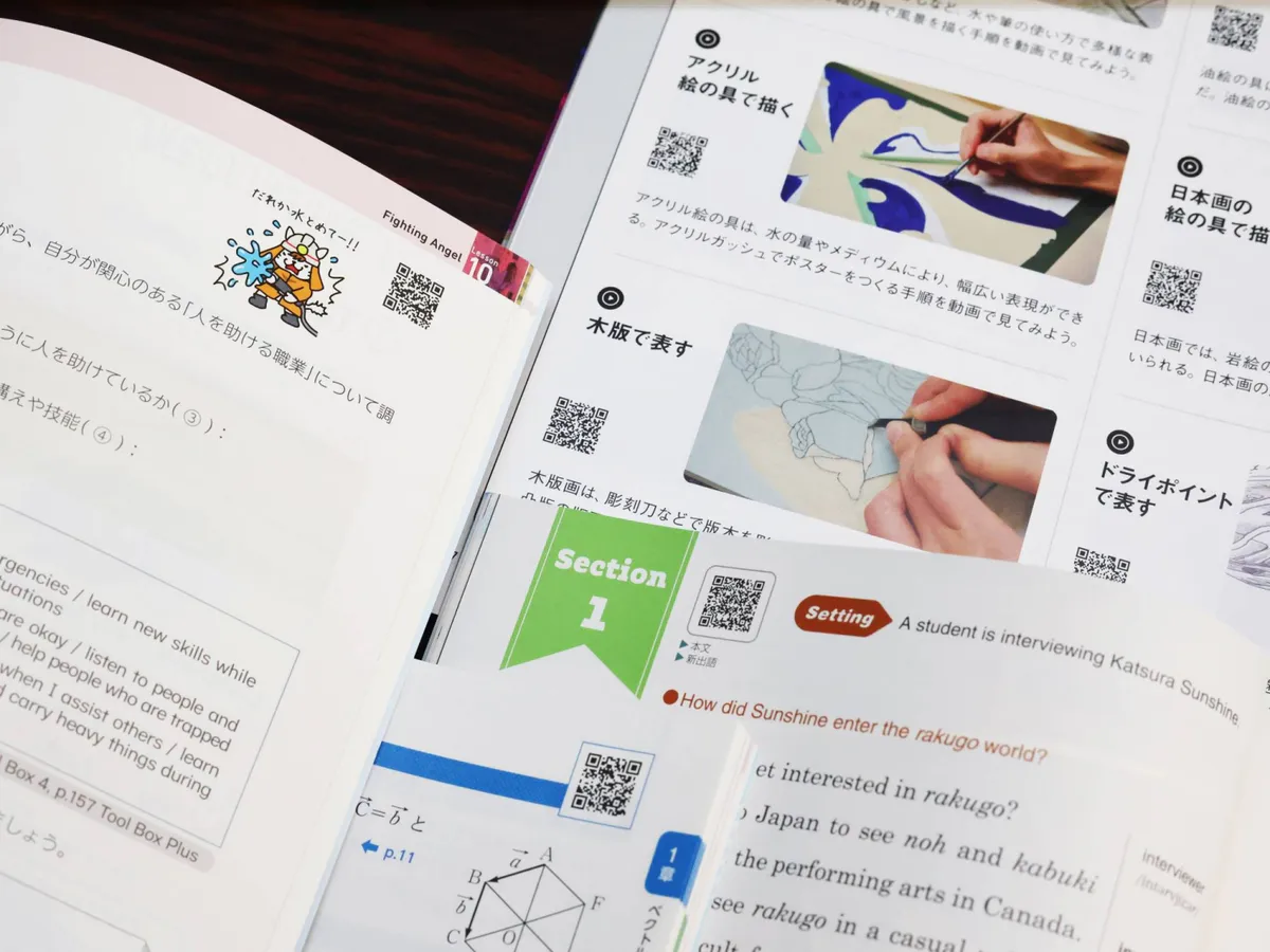 Printed schoolbooks beside a tablet on a classroom desk