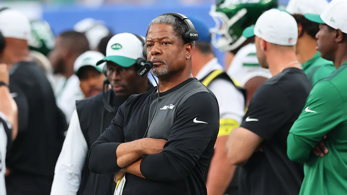 Football coaching playbook beside a whistle on a desk