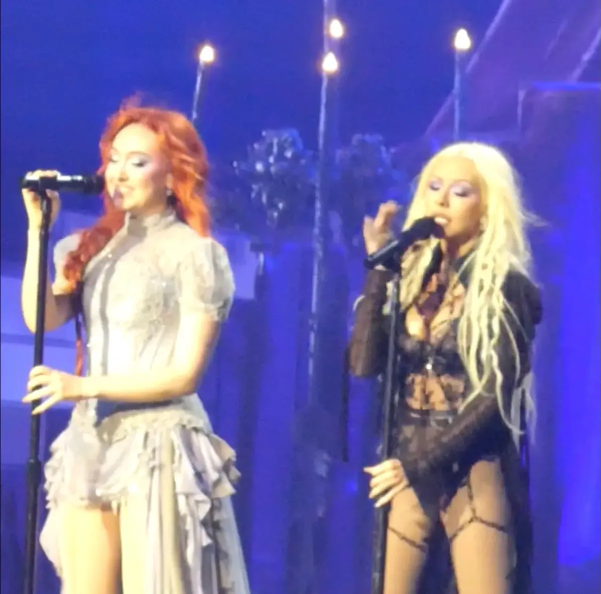 Two microphones on a concert stage under spotlights