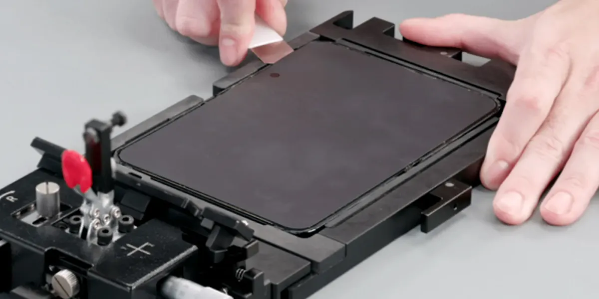 Smartphone components arranged beside electronics repair tools