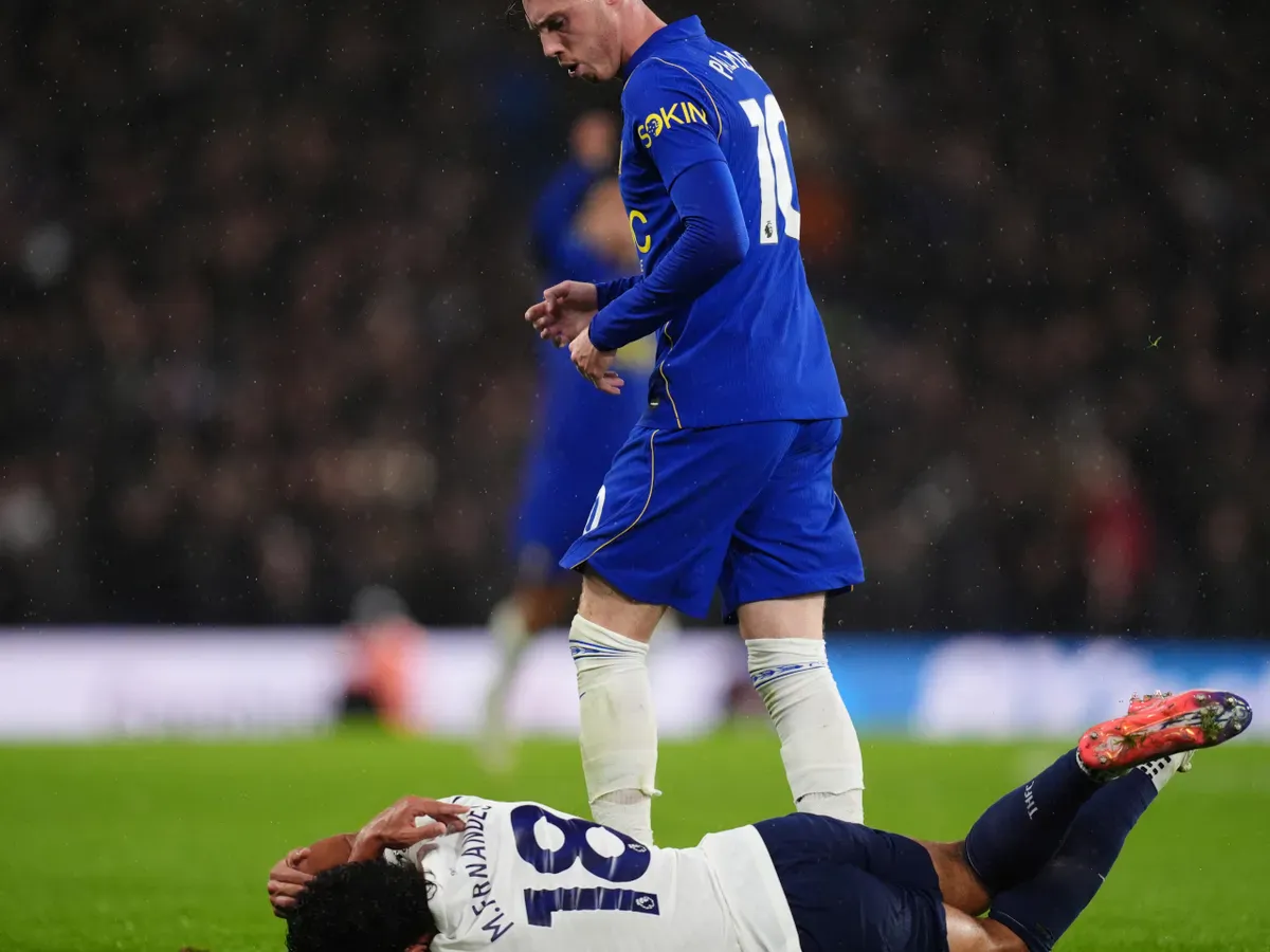 A referee holding a red card on a soccer field
