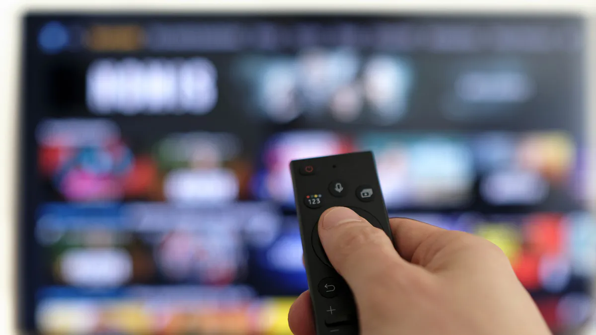 Television screen with streaming app icons and a remote control nearby