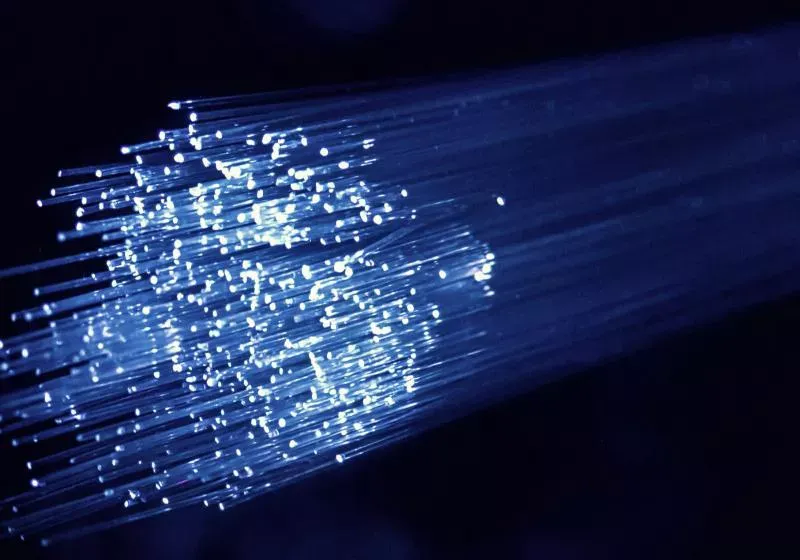 Optical fiber strands beside networking equipment