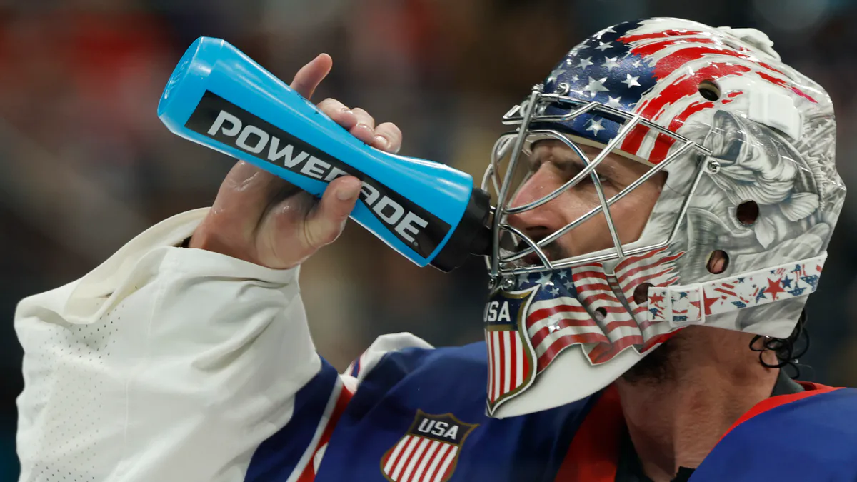 Hockey goalie positioned in front of a net on an ice rink