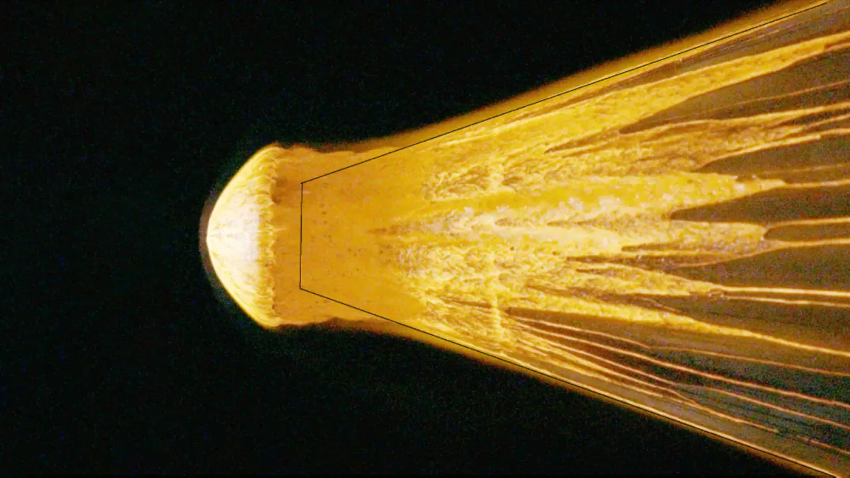 Illustration of a glowing space rock breaking into fragments in Earth's atmosphere