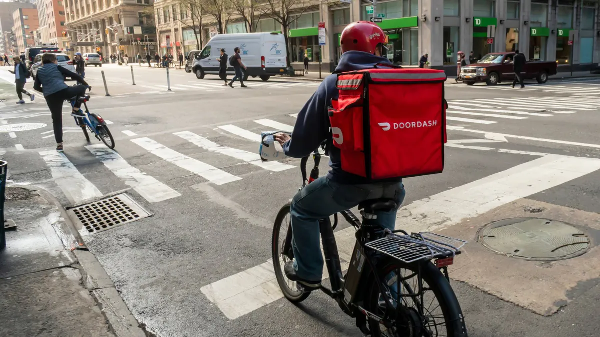 Grocery bags beside a smartphone displaying a delivery app