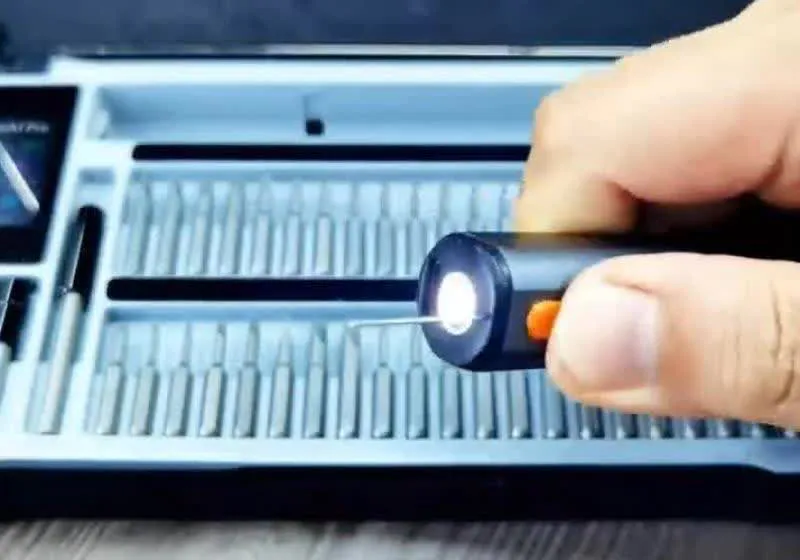 Electric screwdriver beside interchangeable bits on a workbench
