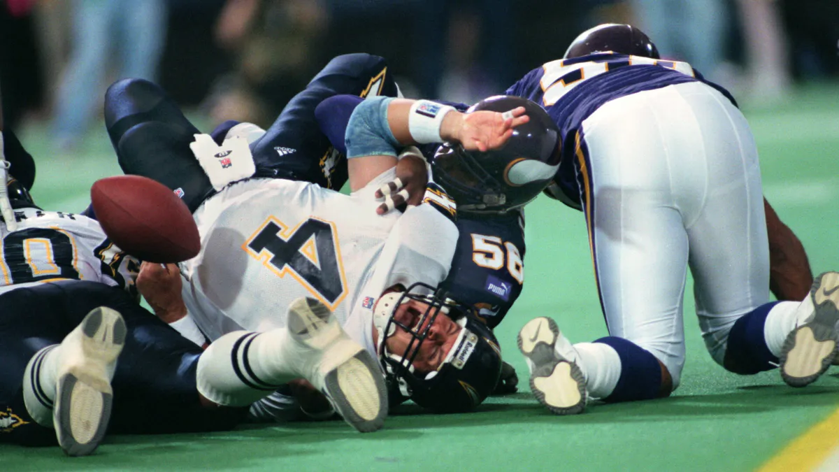 Football and helmet on a field near a yard line