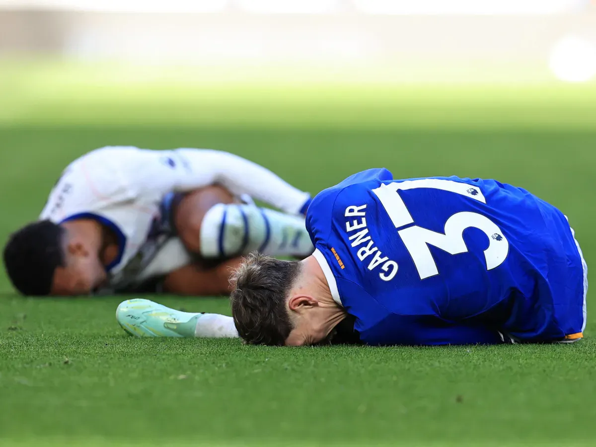 A yellow card and a red card beside a soccer ball on grass